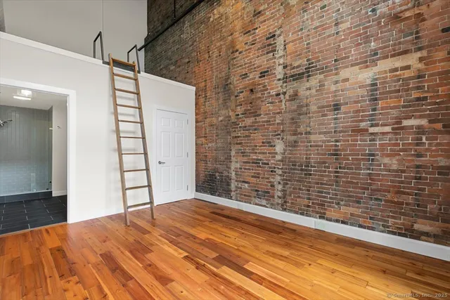 a view of empty room with wooden floor
