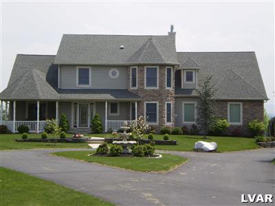a front view of a house with garden and outdoor seating