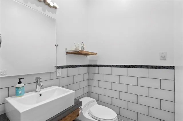 a bathroom with a sink toilet and a mirror