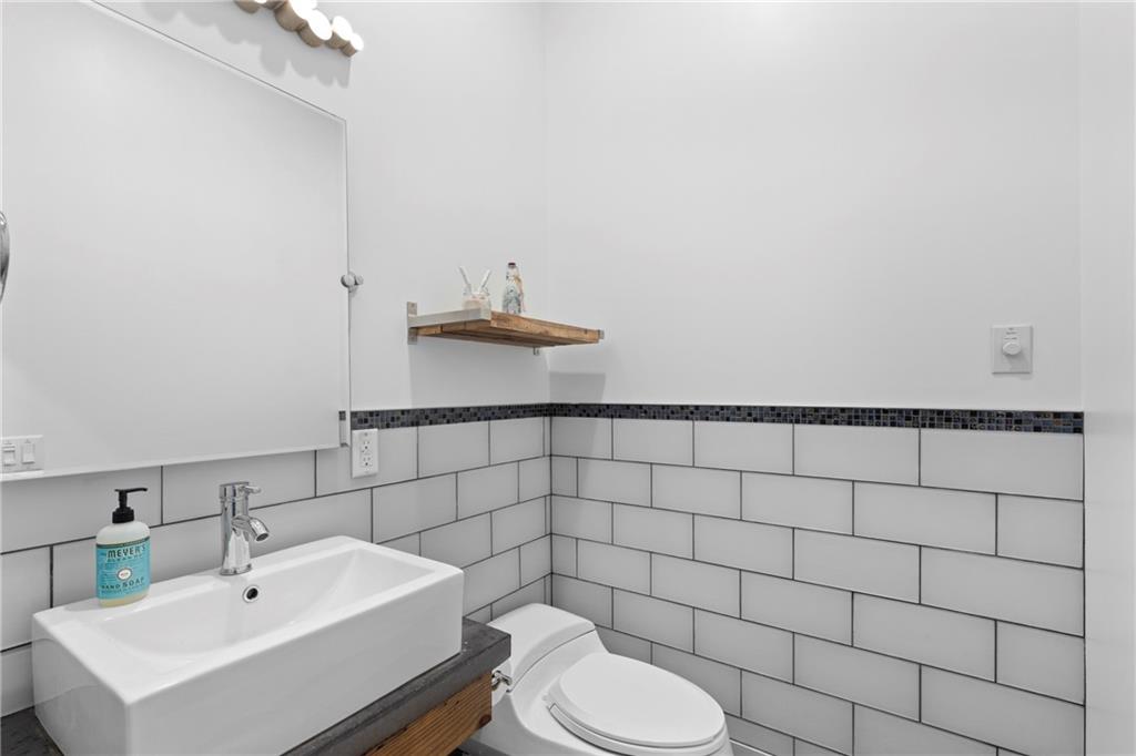 560 John Wesley Dobbs Avenue Northeast, Unit A Atlanta, GA 30312 - Photo 13 of 44 a bathroom with a sink toilet and a mirror