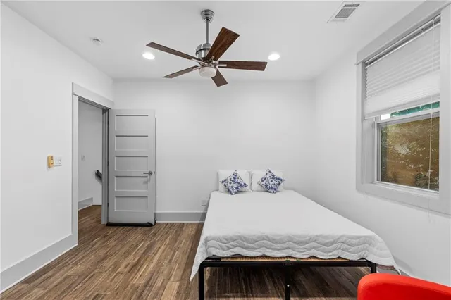 a bedroom with a bed and wooden floor