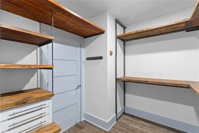 a view of a hallway with wooden floor and a window