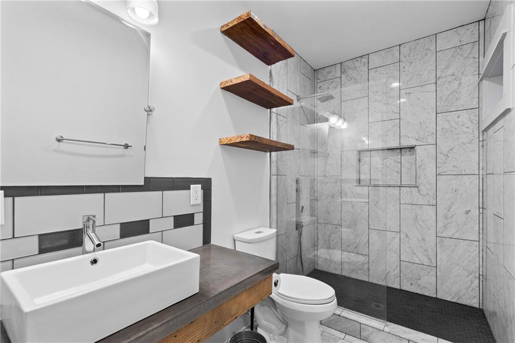 560 John Wesley Dobbs Avenue Northeast, Unit A Atlanta, GA 30312 - Photo 37 of 44 a bathroom with a sink a toilet and shower