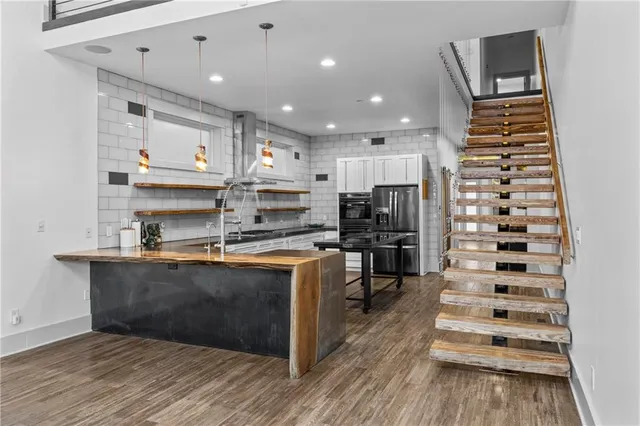 a kitchen with stainless steel appliances kitchen island granite countertop a refrigerator and a stove top oven