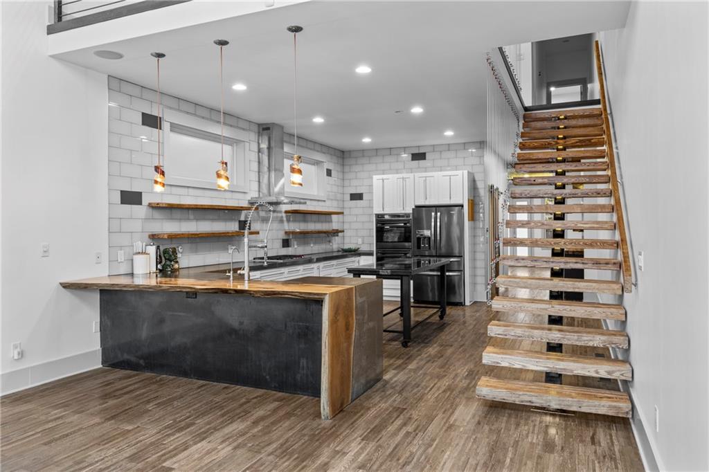 560 John Wesley Dobbs Avenue Northeast, Unit A Atlanta, GA 30312 - Photo 5 of 44 a kitchen with stainless steel appliances kitchen island granite countertop a refrigerator and a stove top oven