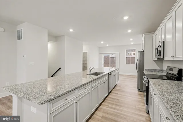 a large kitchen with kitchen island granite countertop a large counter top and wooden floor