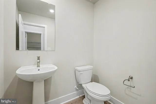 a bathroom with a toilet a sink and mirror