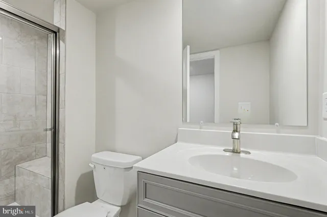 a bathroom with a sink a toilet a mirror and shower