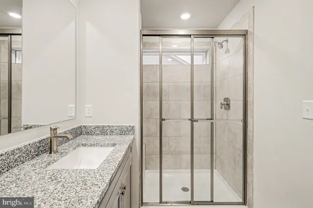 a bathroom with a granite countertop sink and a mirror