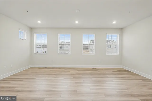 a view of empty room with wooden floor and window