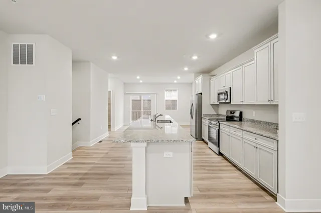 a large kitchen with kitchen island a sink stainless steel appliances and cabinets