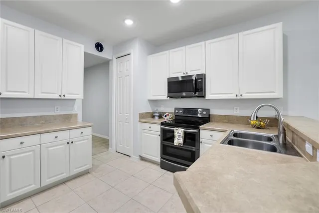 a kitchen with granite countertop a stove sink and microwave