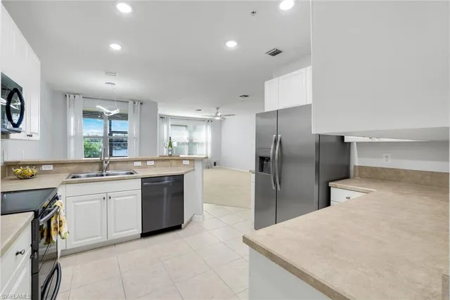 a large kitchen with a large counter top stainless steel appliances and cabinets