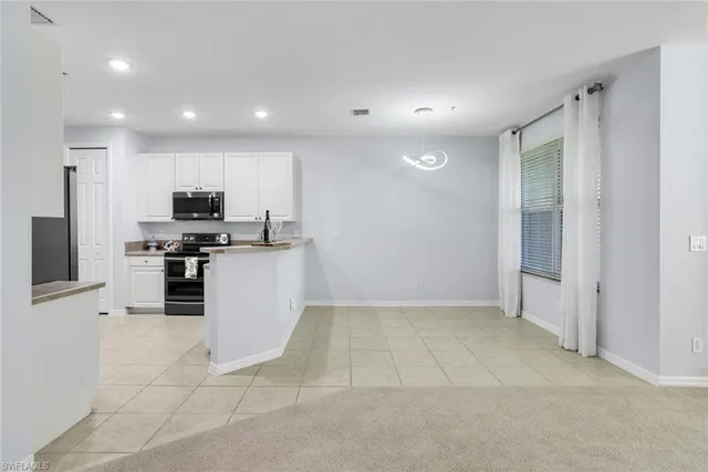 a kitchen with granite countertop a refrigerator and a stove top oven