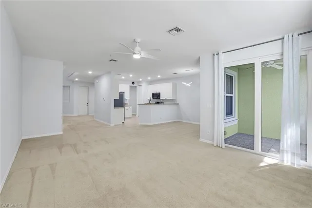 a view of a big room with a large windows and refrigerator