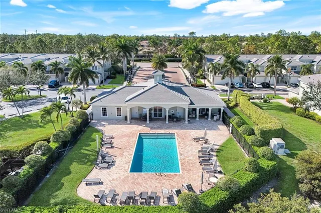 an aerial view of residential houses with yard and lake view