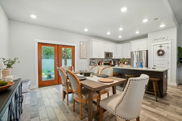 a living room with stainless steel appliances kitchen island granite countertop furniture a refrigerator a table and chairs