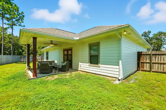 a view of backyard with a garden and wooden fence