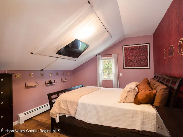 a bedroom with a bed and a painting on the wall