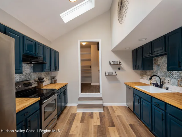 a kitchen with granite countertop stainless steel appliances a sink stove and refrigerator