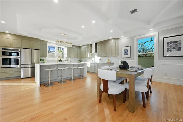 a living room with stainless steel appliances kitchen island granite countertop furniture and wooden floor