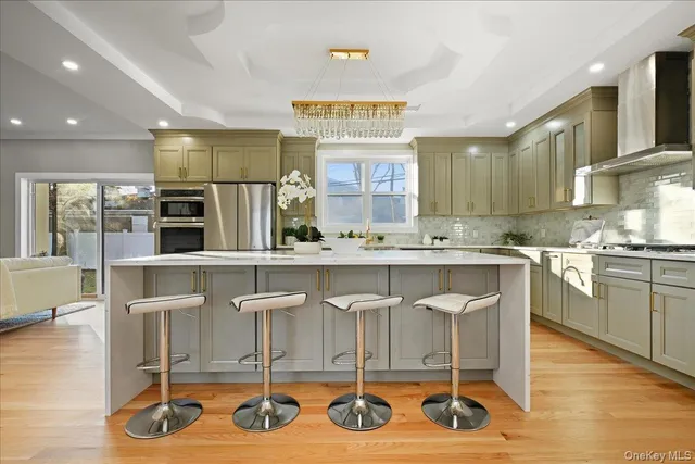 a room with stainless steel appliances kitchen island granite countertop a stove and cabinets