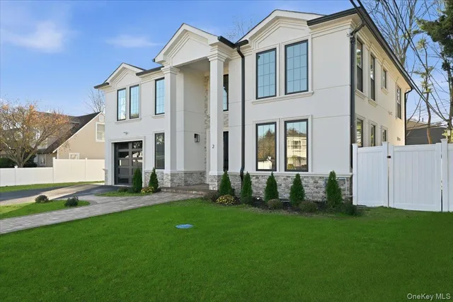 a front view of a house with a garden and yard