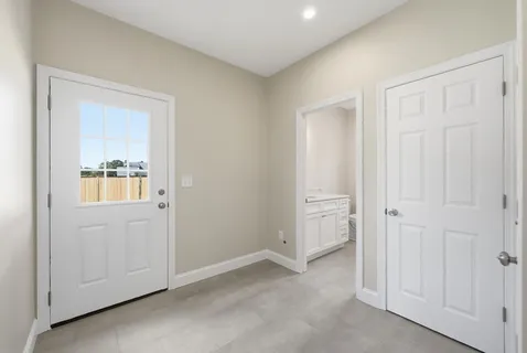 an empty room with windows and closet area