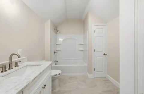 a bathroom with a granite countertop sink a toilet and shower
