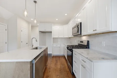 a kitchen with stainless steel appliances granite countertop a sink stove and cabinets