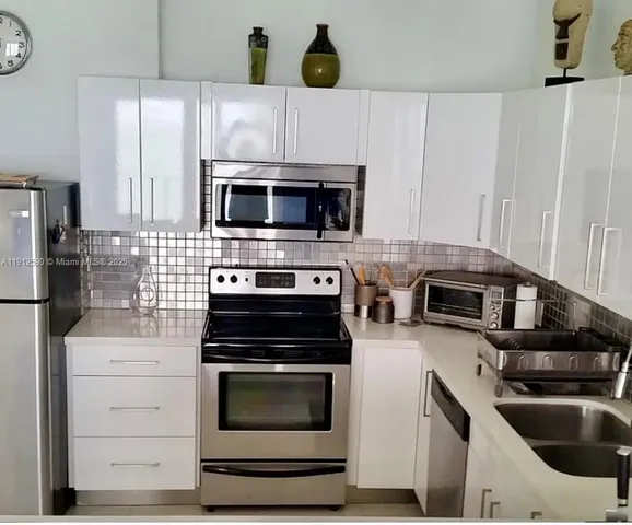 a kitchen with cabinets stainless steel appliances and wooden floor