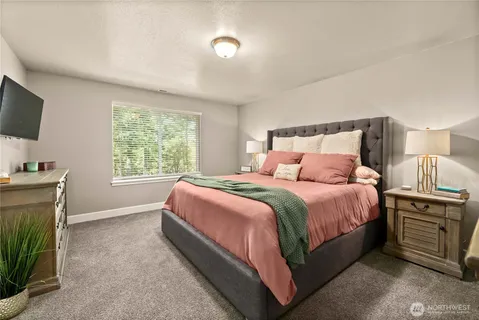 a spacious bedroom with a bed and a flat screen tv