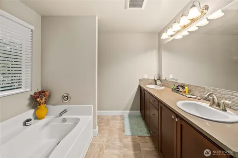 a bathroom with a tub sink and mirror