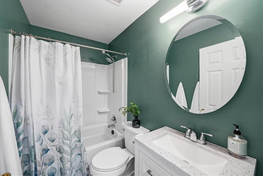 5638 Nacoochee Street Lula, GA 30554 - Photo 13 of 29 a bathroom with a toilet a sink a mirror a bathtub and shower