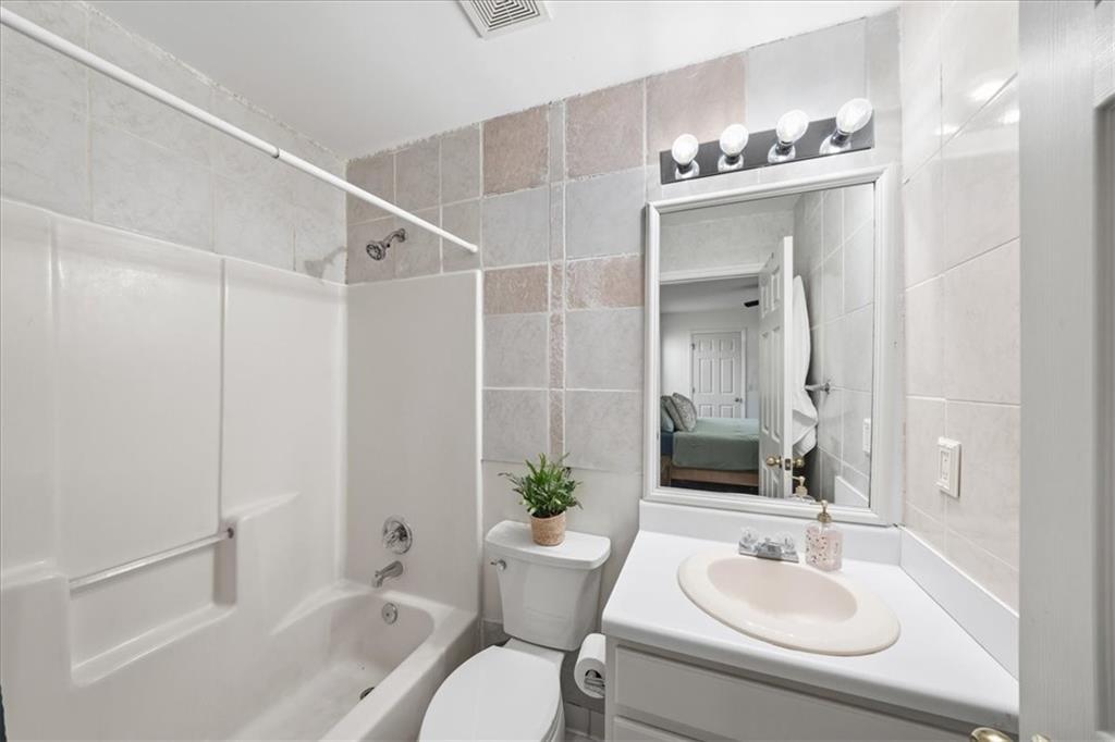 5638 Nacoochee Street Lula, GA 30554 - Photo 17 of 29 a bathroom with a sink toilet a large mirror a bathtub and shower