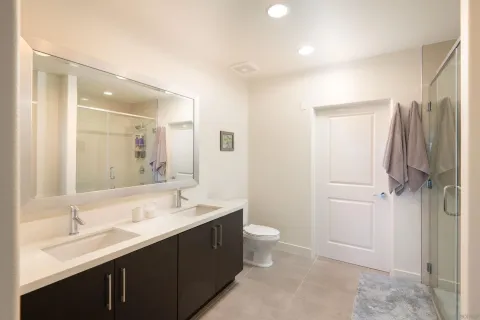 a bathroom with a double vanity sink toilet mirror and