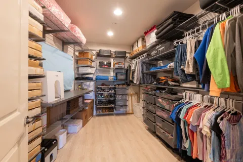 a view of walk in closet with clothes and shoes