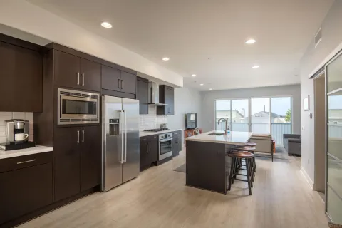 a kitchen with kitchen island a counter top space a sink stainless steel appliances and cabinets
