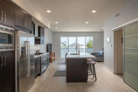 a kitchen with stainless steel appliances kitchen island granite countertop a refrigerator a sink a stove and a refrigerator