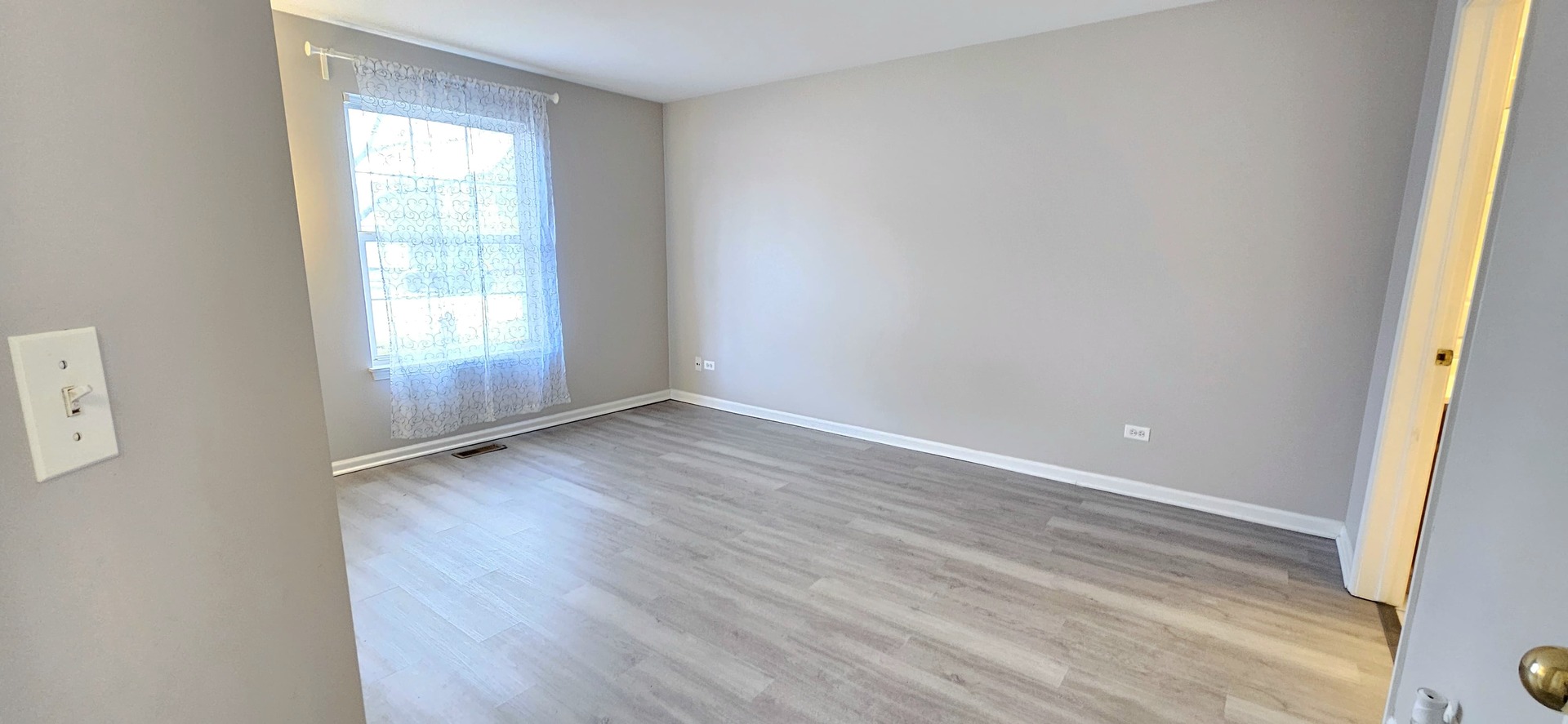 1248 North Red Oak Circle, Unit 2 Round Lake Beach, IL 60073 - Photo 12 of 21 an empty room with wooden floor and windows