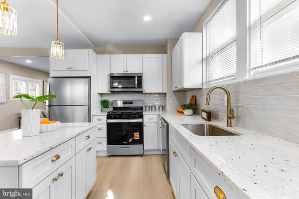 a kitchen with a sink a counter appliances and cabinets
