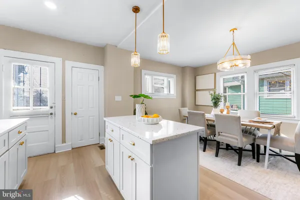 a view of a dining room and livingroom with furniture wooden floor a chandelier
