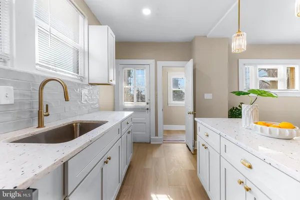 a kitchen with granite countertop a sink a counter top space and living room
