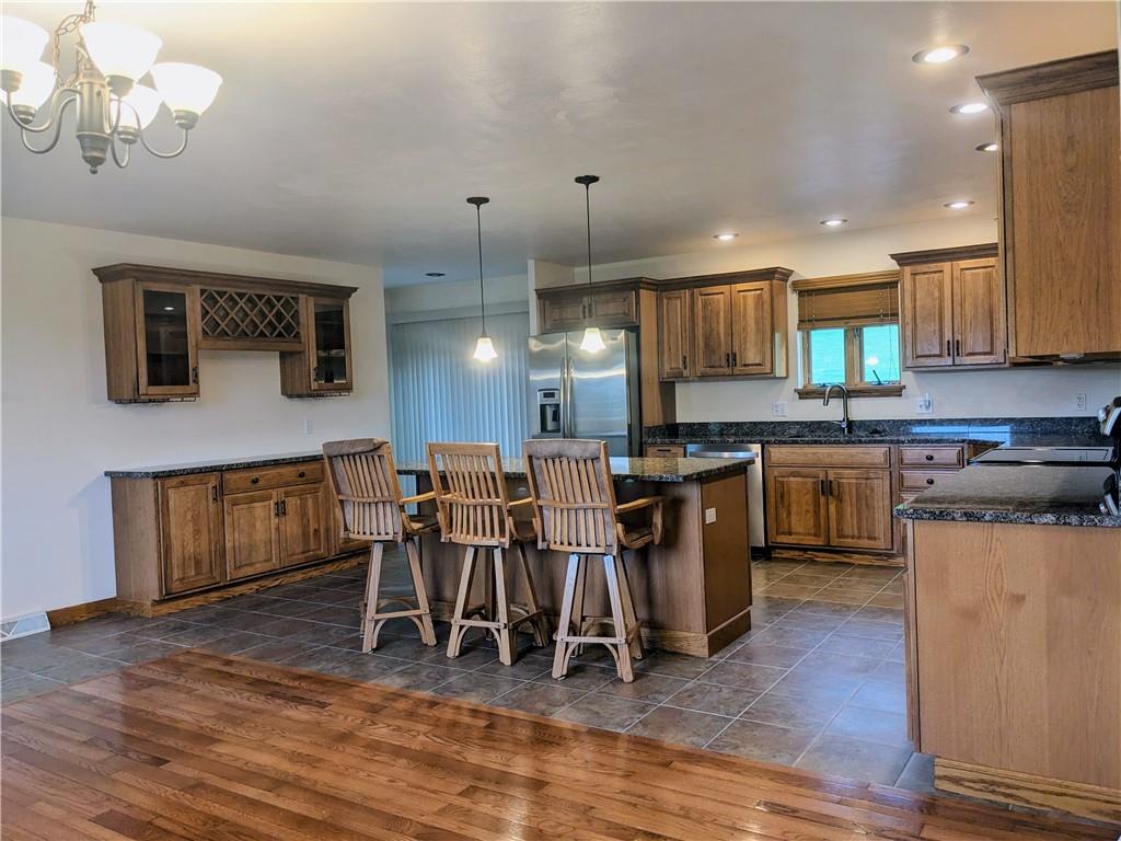 350 American Legion Road Latrobe, PA 15650 - Photo 10 of 45 a kitchen with stainless steel appliances granite countertop a stove top oven a sink dishwasher a dining table and chairs with wooden floor