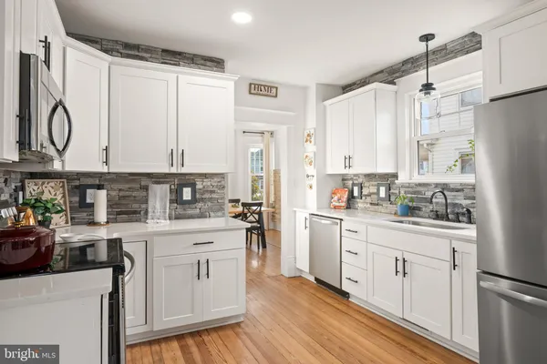 a kitchen with white cabinets and white appliances