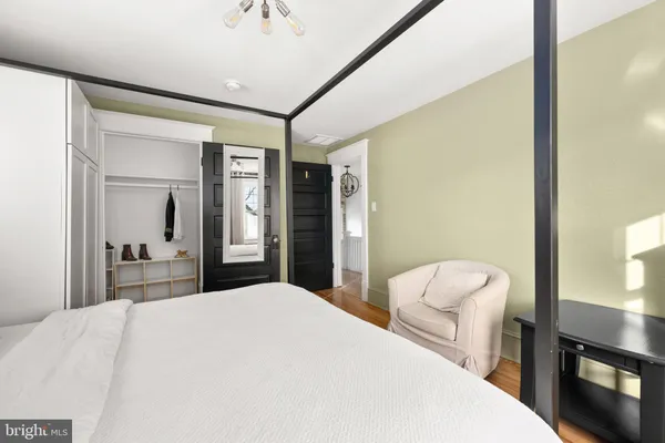 a bedroom with a bed and a mirror on dresser