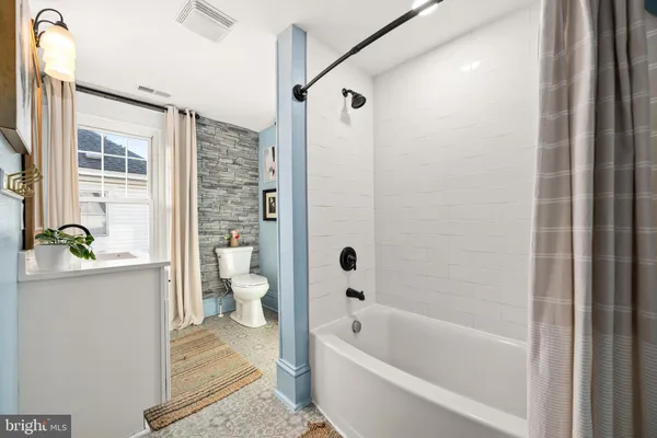a bathroom with a granite countertop toilet a sink and bathtub