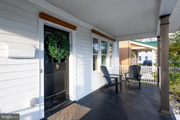 a view of a porch with chairs and potted plants