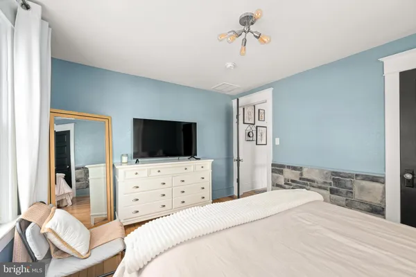 a bedroom with a bed and a flat screen tv