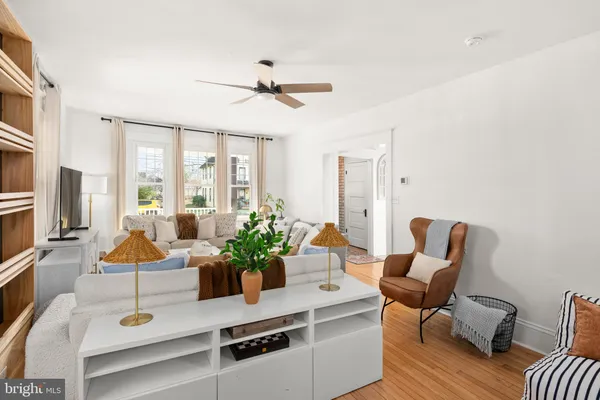 a living room with furniture ceiling fan and a window